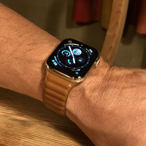 Cinturino Leather Link per Apple Watch indossato al polso, con la fascia magnetica avvolta intorno al braccio
